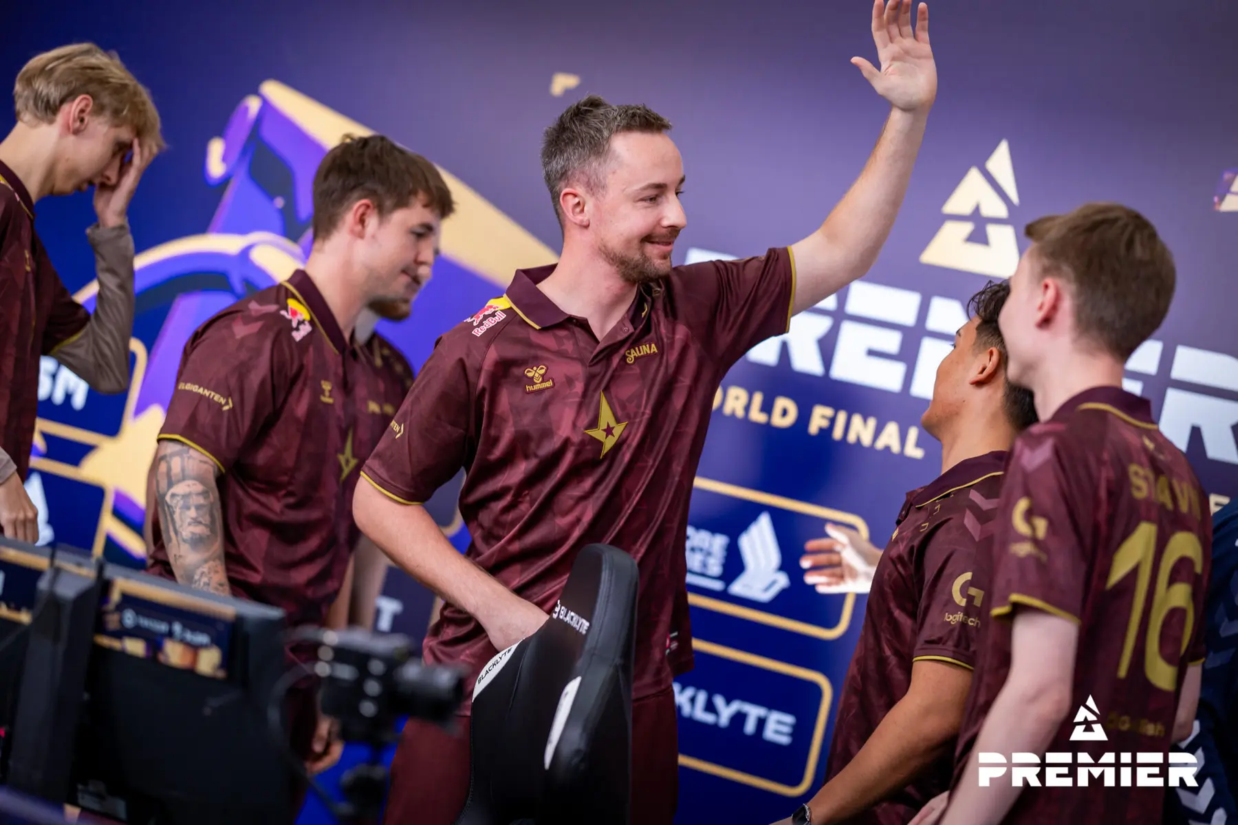 Astralis CS2 team members in maroon jerseys celebrating at a Premier World Final event