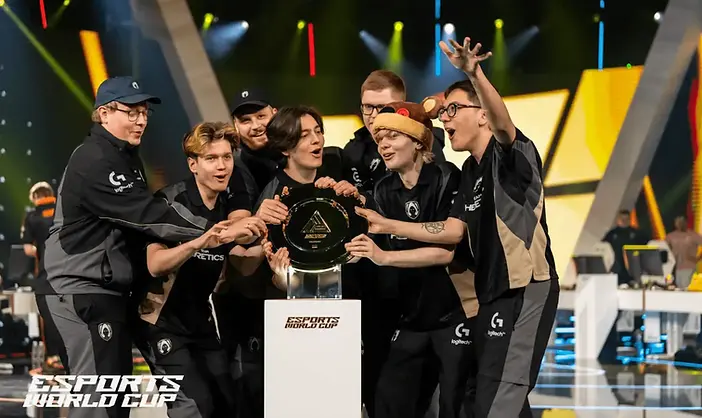 Team celebrating victory at the Esports World Cup with a trophy.