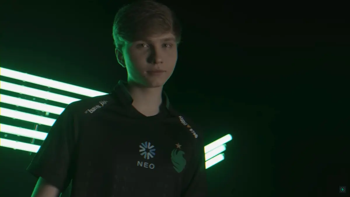 A young esports player wearing a CS2 Falcons jersey with green lighting.