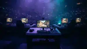 Professional esports arena stage with gaming setups under dramatic purple and cyan lighting during CS2 tournament