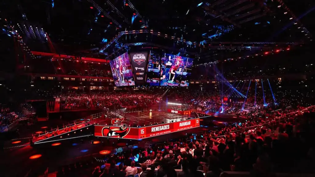 A crowded esports arena with colorful lights for a CS:GO tournament.