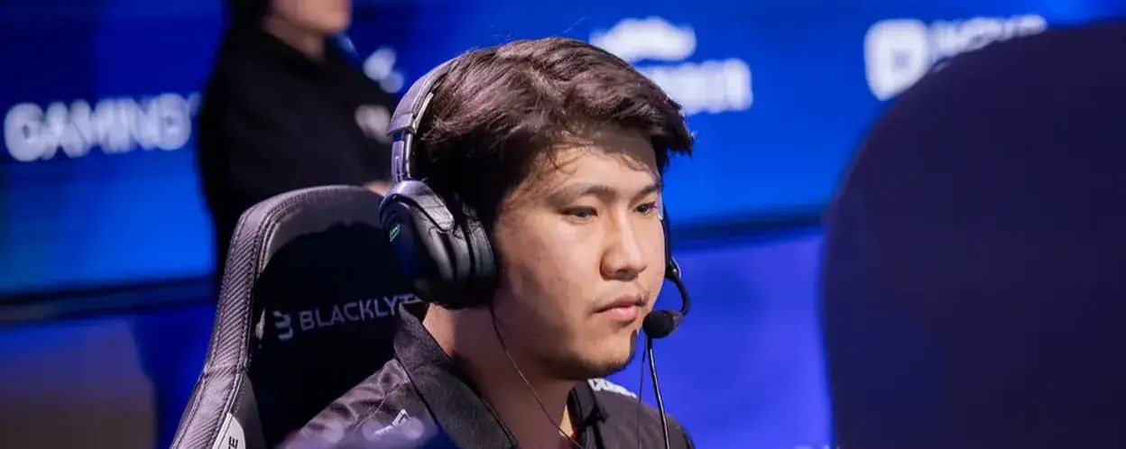 A focused esports player wearing headphones during a tournament.