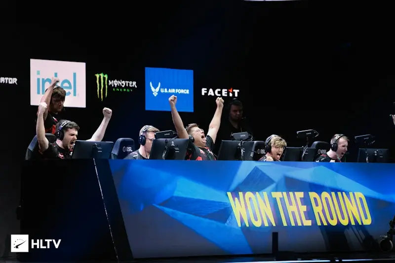 Virtus.pro CS2 players celebrating a round win at a professional tournament with sponsor logos in the background
