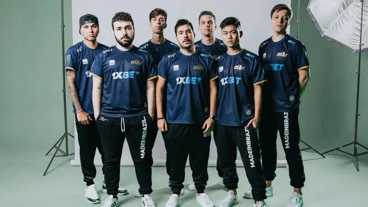Six members of the MIBR esports team posing in blue team jerseys and black joggers in a studio.