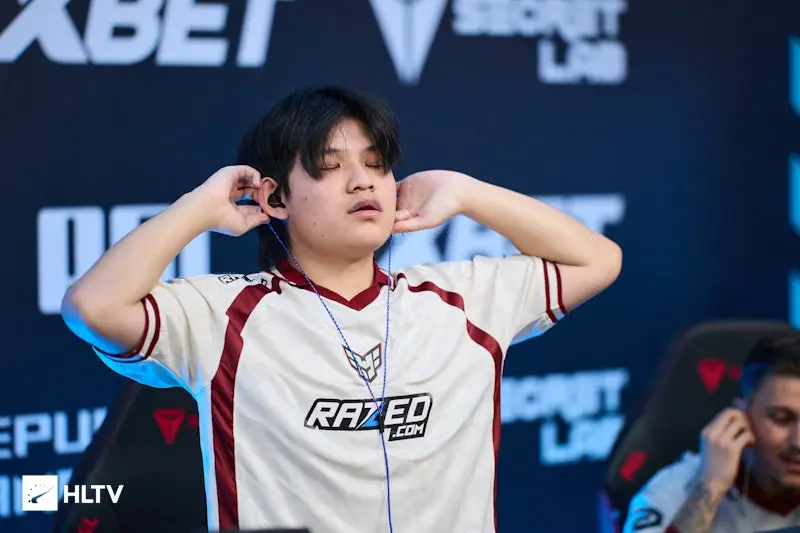 Simon yxngstxr Boye wearing a Razored team jersey and adjusting his in-ear monitors at a CS2 event.
